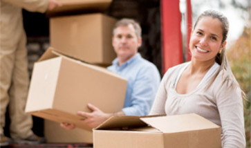 Woman and man loading boxes onto moving truck